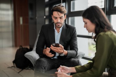 İş adamları iş yerinde eğleniyor ve sohbet ediyorlar. Erkek ve bayan meslektaşlar ortak çalışma alanında tanışmaktan hoşlanırlar. İş arkadaşlarım ofiste projeyi tartışıyorlar..