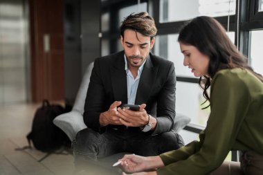 İş adamları iş yerinde eğleniyor ve sohbet ediyorlar. Erkek ve bayan meslektaşlar ortak çalışma alanında tanışmaktan hoşlanırlar. İş arkadaşlarım ofiste projeyi tartışıyorlar..