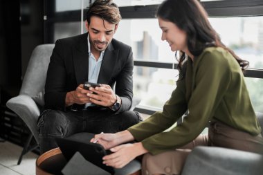 İş adamları iş yerinde eğleniyor ve sohbet ediyorlar. Erkek ve bayan meslektaşlar ortak çalışma alanında tanışmaktan hoşlanırlar. İş arkadaşlarım ofiste projeyi tartışıyorlar..