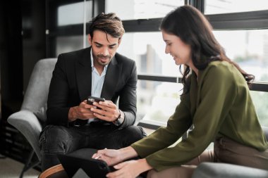 İş adamları iş yerinde eğleniyor ve sohbet ediyorlar. Erkek ve bayan meslektaşlar ortak çalışma alanında tanışmaktan hoşlanırlar. İş arkadaşlarım ofiste projeyi tartışıyorlar..