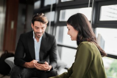 İş adamları iş yerinde eğleniyor ve sohbet ediyorlar. Erkek ve bayan meslektaşlar ortak çalışma alanında tanışmaktan hoşlanırlar. İş arkadaşlarım ofiste projeyi tartışıyorlar..