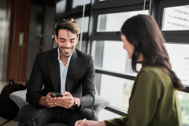 İş adamları iş yerinde eğleniyor ve sohbet ediyorlar. Erkek ve bayan meslektaşlar ortak çalışma alanında tanışmaktan hoşlanırlar. İş arkadaşlarım ofiste projeyi tartışıyorlar..