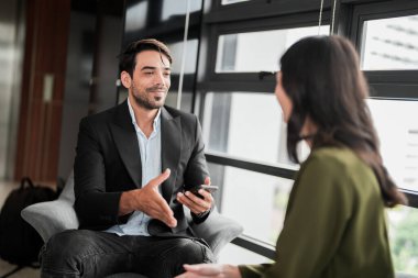 İş adamları iş yerinde eğleniyor ve sohbet ediyorlar. Erkek ve bayan meslektaşlar ortak çalışma alanında tanışmaktan hoşlanırlar. İş arkadaşlarım ofiste projeyi tartışıyorlar..