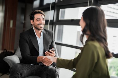 İş adamları iş yerinde eğleniyor ve sohbet ediyorlar. Erkek ve bayan meslektaşlar ortak çalışma alanında tanışmaktan hoşlanırlar. İş arkadaşlarım ofiste projeyi tartışıyorlar..