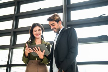 İş adamları iş yerinde eğleniyor ve sohbet ediyorlar. Erkek ve bayan meslektaşlar ortak çalışma alanında tanışmaktan hoşlanırlar. İş arkadaşlarım ofiste projeyi tartışıyorlar..