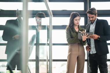 İş adamları iş yerinde eğleniyor ve sohbet ediyorlar. Erkek ve bayan meslektaşlar ortak çalışma alanında tanışmaktan hoşlanırlar. İş arkadaşlarım ofiste projeyi tartışıyorlar..