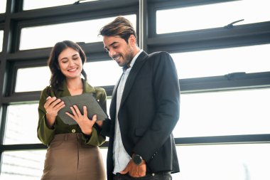 İş adamları iş yerinde eğleniyor ve sohbet ediyorlar. Erkek ve bayan meslektaşlar ortak çalışma alanında tanışmaktan hoşlanırlar. İş arkadaşlarım ofiste projeyi tartışıyorlar..