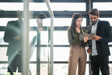 İş adamları iş yerinde eğleniyor ve sohbet ediyorlar. Erkek ve bayan meslektaşlar ortak çalışma alanında tanışmaktan hoşlanırlar. İş arkadaşlarım ofiste projeyi tartışıyorlar..