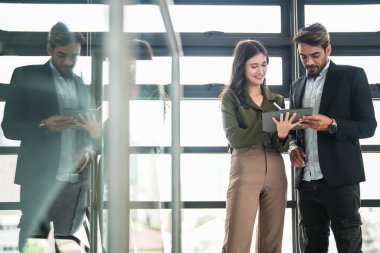 İş adamları iş yerinde eğleniyor ve sohbet ediyorlar. Erkek ve bayan meslektaşlar ortak çalışma alanında tanışmaktan hoşlanırlar. İş arkadaşlarım ofiste projeyi tartışıyorlar..