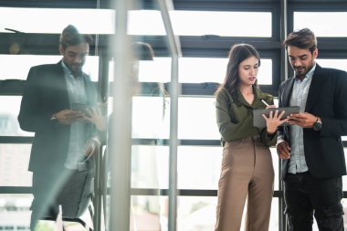 İş adamları iş yerinde eğleniyor ve sohbet ediyorlar. Erkek ve bayan meslektaşlar ortak çalışma alanında tanışmaktan hoşlanırlar. İş arkadaşlarım ofiste projeyi tartışıyorlar..