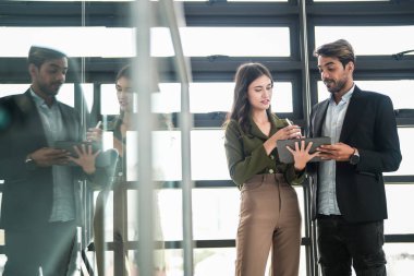 İş adamları iş yerinde eğleniyor ve sohbet ediyorlar. Erkek ve bayan meslektaşlar ortak çalışma alanında tanışmaktan hoşlanırlar. İş arkadaşlarım ofiste projeyi tartışıyorlar..