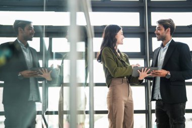 İş adamları iş yerinde eğleniyor ve sohbet ediyorlar. Erkek ve bayan meslektaşlar ortak çalışma alanında tanışmaktan hoşlanırlar. İş arkadaşlarım ofiste projeyi tartışıyorlar..