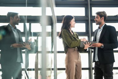 İş adamları iş yerinde eğleniyor ve sohbet ediyorlar. Erkek ve bayan meslektaşlar ortak çalışma alanında tanışmaktan hoşlanırlar. İş arkadaşlarım ofiste projeyi tartışıyorlar..