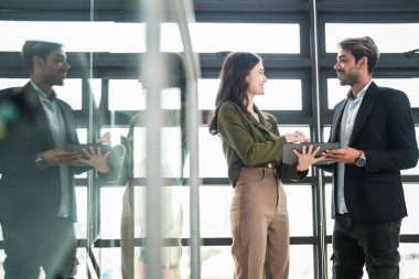 İş adamları iş yerinde eğleniyor ve sohbet ediyorlar. Erkek ve bayan meslektaşlar ortak çalışma alanında tanışmaktan hoşlanırlar. İş arkadaşlarım ofiste projeyi tartışıyorlar..