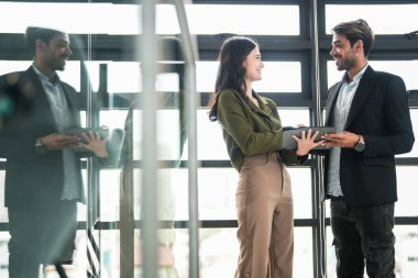 İş adamları iş yerinde eğleniyor ve sohbet ediyorlar. Erkek ve bayan meslektaşlar ortak çalışma alanında tanışmaktan hoşlanırlar. İş arkadaşlarım ofiste projeyi tartışıyorlar..