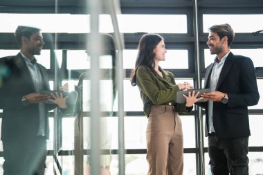 İş adamları iş yerinde eğleniyor ve sohbet ediyorlar. Erkek ve bayan meslektaşlar ortak çalışma alanında tanışmaktan hoşlanırlar. İş arkadaşlarım ofiste projeyi tartışıyorlar..