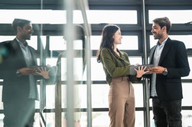 İş adamları iş yerinde eğleniyor ve sohbet ediyorlar. Erkek ve bayan meslektaşlar ortak çalışma alanında tanışmaktan hoşlanırlar. İş arkadaşlarım ofiste projeyi tartışıyorlar..