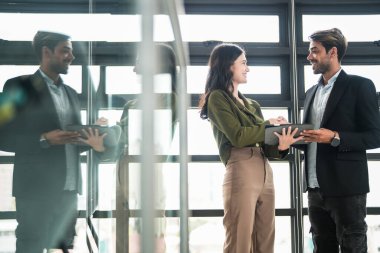 İş adamları iş yerinde eğleniyor ve sohbet ediyorlar. Erkek ve bayan meslektaşlar ortak çalışma alanında tanışmaktan hoşlanırlar. İş arkadaşlarım ofiste projeyi tartışıyorlar..