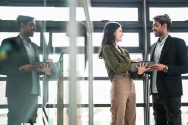 İş adamları iş yerinde eğleniyor ve sohbet ediyorlar. Erkek ve bayan meslektaşlar ortak çalışma alanında tanışmaktan hoşlanırlar. İş arkadaşlarım ofiste projeyi tartışıyorlar..