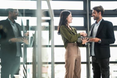 İş adamları iş yerinde eğleniyor ve sohbet ediyorlar. Erkek ve bayan meslektaşlar ortak çalışma alanında tanışmaktan hoşlanırlar. İş arkadaşlarım ofiste projeyi tartışıyorlar..