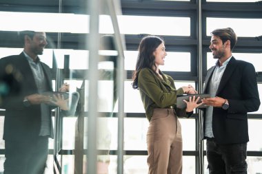 İş adamları iş yerinde eğleniyor ve sohbet ediyorlar. Erkek ve bayan meslektaşlar ortak çalışma alanında tanışmaktan hoşlanırlar. İş arkadaşlarım ofiste projeyi tartışıyorlar..