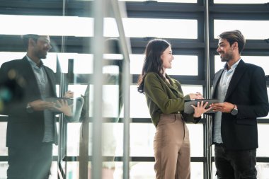 İş adamları iş yerinde eğleniyor ve sohbet ediyorlar. Erkek ve bayan meslektaşlar ortak çalışma alanında tanışmaktan hoşlanırlar. İş arkadaşlarım ofiste projeyi tartışıyorlar..