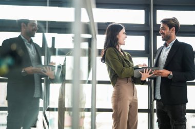 İş adamları iş yerinde eğleniyor ve sohbet ediyorlar. Erkek ve bayan meslektaşlar ortak çalışma alanında tanışmaktan hoşlanırlar. İş arkadaşlarım ofiste projeyi tartışıyorlar..