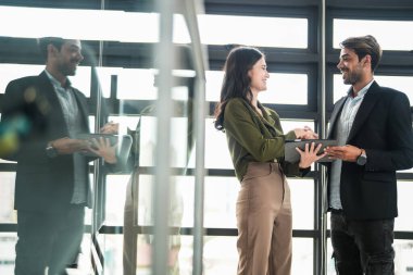 İş adamları iş yerinde eğleniyor ve sohbet ediyorlar. Erkek ve bayan meslektaşlar ortak çalışma alanında tanışmaktan hoşlanırlar. İş arkadaşlarım ofiste projeyi tartışıyorlar..