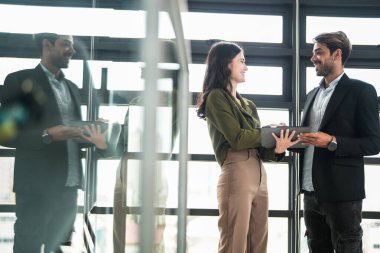 İş adamları iş yerinde eğleniyor ve sohbet ediyorlar. Erkek ve bayan meslektaşlar ortak çalışma alanında tanışmaktan hoşlanırlar. İş arkadaşlarım ofiste projeyi tartışıyorlar..