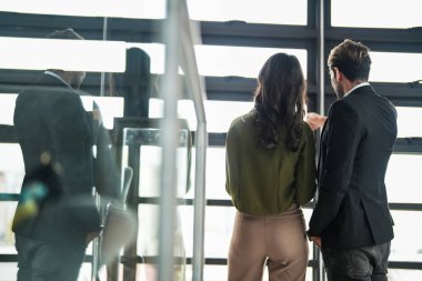 İş adamları iş yerinde eğleniyor ve sohbet ediyorlar. Erkek ve bayan meslektaşlar ortak çalışma alanında tanışmaktan hoşlanırlar. İş arkadaşlarım ofiste projeyi tartışıyorlar..