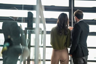 İş adamları iş yerinde eğleniyor ve sohbet ediyorlar. Erkek ve bayan meslektaşlar ortak çalışma alanında tanışmaktan hoşlanırlar. İş arkadaşlarım ofiste projeyi tartışıyorlar..