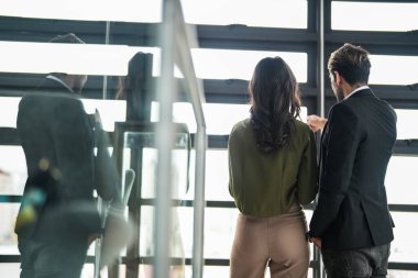 İş adamları iş yerinde eğleniyor ve sohbet ediyorlar. Erkek ve bayan meslektaşlar ortak çalışma alanında tanışmaktan hoşlanırlar. İş arkadaşlarım ofiste projeyi tartışıyorlar..