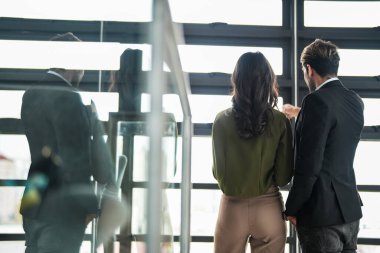 İş adamları iş yerinde eğleniyor ve sohbet ediyorlar. Erkek ve bayan meslektaşlar ortak çalışma alanında tanışmaktan hoşlanırlar. İş arkadaşlarım ofiste projeyi tartışıyorlar..