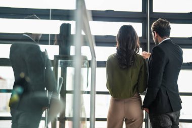 İş adamları iş yerinde eğleniyor ve sohbet ediyorlar. Erkek ve bayan meslektaşlar ortak çalışma alanında tanışmaktan hoşlanırlar. İş arkadaşlarım ofiste projeyi tartışıyorlar..