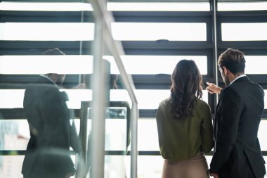 İş adamları iş yerinde eğleniyor ve sohbet ediyorlar. Erkek ve bayan meslektaşlar ortak çalışma alanında tanışmaktan hoşlanırlar. İş arkadaşlarım ofiste projeyi tartışıyorlar..