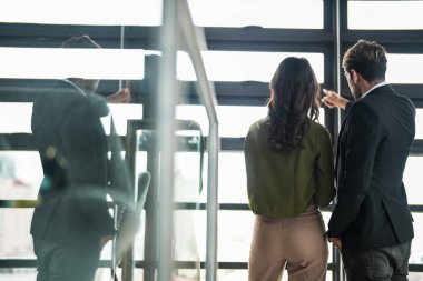 İş adamları iş yerinde eğleniyor ve sohbet ediyorlar. Erkek ve bayan meslektaşlar ortak çalışma alanında tanışmaktan hoşlanırlar. İş arkadaşlarım ofiste projeyi tartışıyorlar..