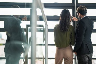 İş adamları iş yerinde eğleniyor ve sohbet ediyorlar. Erkek ve bayan meslektaşlar ortak çalışma alanında tanışmaktan hoşlanırlar. İş arkadaşlarım ofiste projeyi tartışıyorlar..