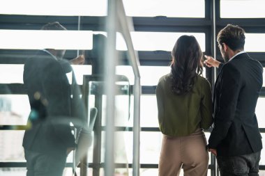 İş adamları iş yerinde eğleniyor ve sohbet ediyorlar. Erkek ve bayan meslektaşlar ortak çalışma alanında tanışmaktan hoşlanırlar. İş arkadaşlarım ofiste projeyi tartışıyorlar..