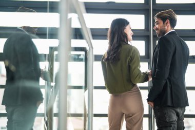 İş adamları iş yerinde eğleniyor ve sohbet ediyorlar. Erkek ve bayan meslektaşlar ortak çalışma alanında tanışmaktan hoşlanırlar. İş arkadaşlarım ofiste projeyi tartışıyorlar..