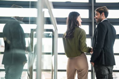 İş adamları iş yerinde eğleniyor ve sohbet ediyorlar. Erkek ve bayan meslektaşlar ortak çalışma alanında tanışmaktan hoşlanırlar. İş arkadaşlarım ofiste projeyi tartışıyorlar..