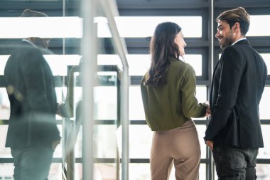 İş adamları iş yerinde eğleniyor ve sohbet ediyorlar. Erkek ve bayan meslektaşlar ortak çalışma alanında tanışmaktan hoşlanırlar. İş arkadaşlarım ofiste projeyi tartışıyorlar..