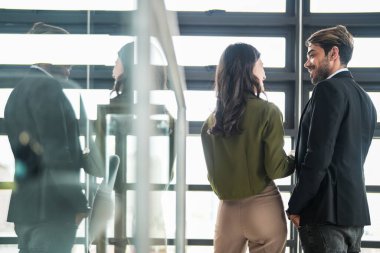 İş adamları iş yerinde eğleniyor ve sohbet ediyorlar. Erkek ve bayan meslektaşlar ortak çalışma alanında tanışmaktan hoşlanırlar. İş arkadaşlarım ofiste projeyi tartışıyorlar..