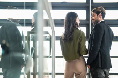 İş adamları iş yerinde eğleniyor ve sohbet ediyorlar. Erkek ve bayan meslektaşlar ortak çalışma alanında tanışmaktan hoşlanırlar. İş arkadaşlarım ofiste projeyi tartışıyorlar..