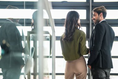 İş adamları iş yerinde eğleniyor ve sohbet ediyorlar. Erkek ve bayan meslektaşlar ortak çalışma alanında tanışmaktan hoşlanırlar. İş arkadaşlarım ofiste projeyi tartışıyorlar..