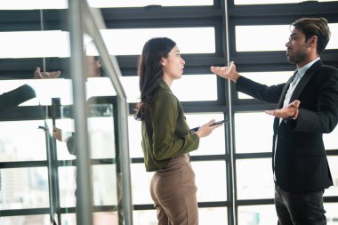 İş adamları iş yerinde eğleniyor ve sohbet ediyorlar. Erkek ve bayan meslektaşlar ortak çalışma alanında tanışmaktan hoşlanırlar. İş arkadaşlarım ofiste projeyi tartışıyorlar..