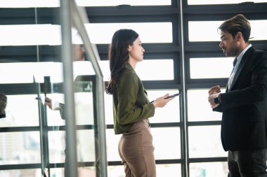 İş adamları iş yerinde eğleniyor ve sohbet ediyorlar. Erkek ve bayan meslektaşlar ortak çalışma alanında tanışmaktan hoşlanırlar. İş arkadaşlarım ofiste projeyi tartışıyorlar..