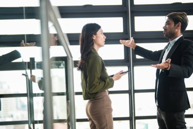 İş adamları iş yerinde eğleniyor ve sohbet ediyorlar. Erkek ve bayan meslektaşlar ortak çalışma alanında tanışmaktan hoşlanırlar. İş arkadaşlarım ofiste projeyi tartışıyorlar..