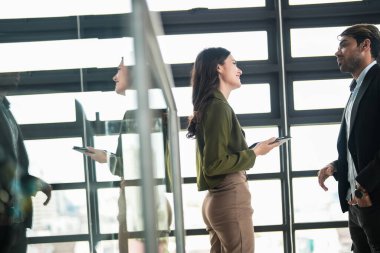 İş adamları iş yerinde eğleniyor ve sohbet ediyorlar. Erkek ve bayan meslektaşlar ortak çalışma alanında tanışmaktan hoşlanırlar. İş arkadaşlarım ofiste projeyi tartışıyorlar..