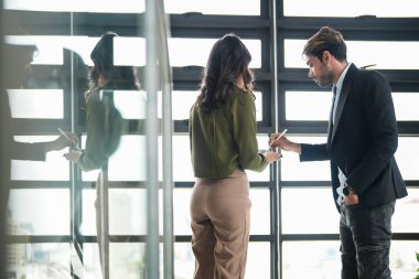 İş adamları iş yerinde eğleniyor ve sohbet ediyorlar. Erkek ve bayan meslektaşlar ortak çalışma alanında tanışmaktan hoşlanırlar. İş arkadaşlarım ofiste projeyi tartışıyorlar..