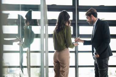 İş adamları iş yerinde eğleniyor ve sohbet ediyorlar. Erkek ve bayan meslektaşlar ortak çalışma alanında tanışmaktan hoşlanırlar. İş arkadaşlarım ofiste projeyi tartışıyorlar..